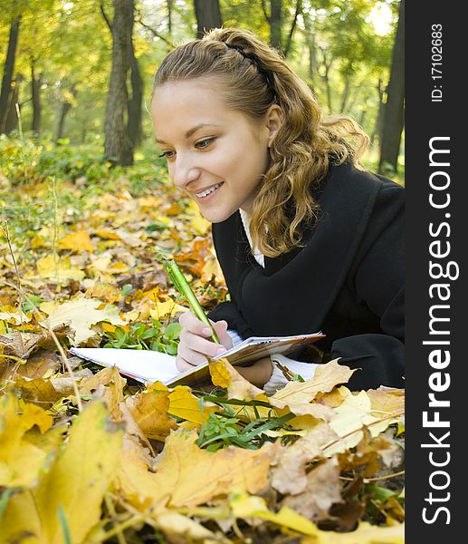 Happy Teen Girl Lies In The Park With Her Diary