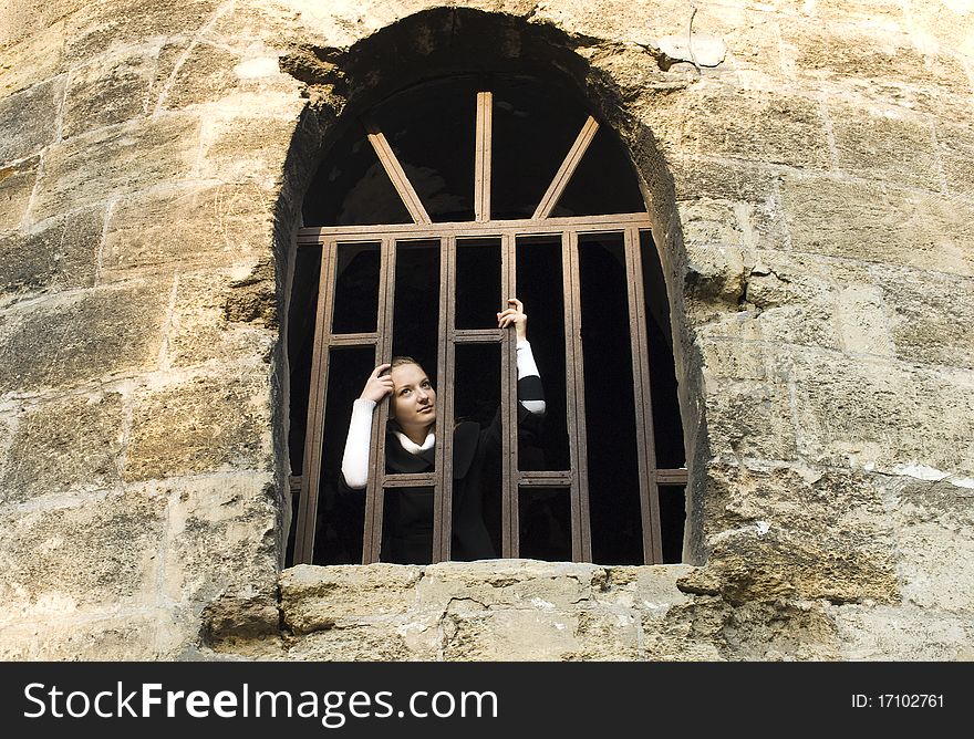 Teen girl looks out of the jail window