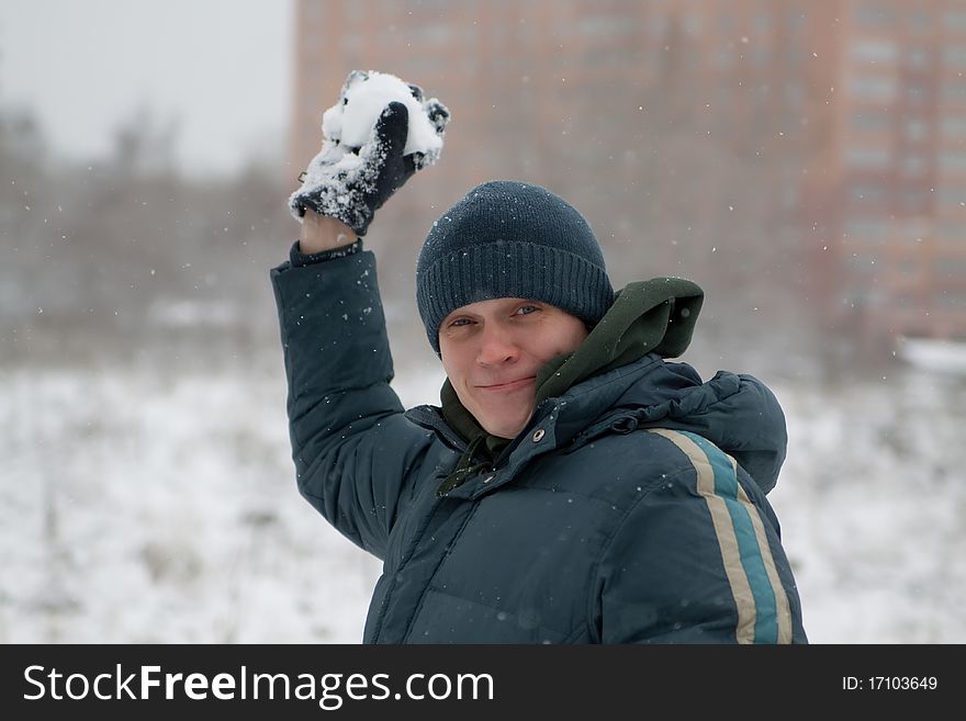 The man plays snowballs, in the winter in the street