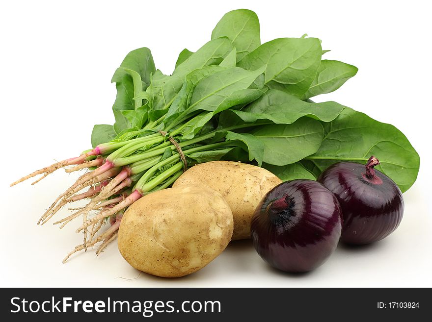 Onions, potatoes and spinach on white