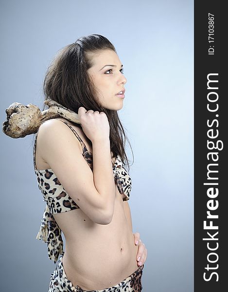 Beautiful prehistoric girl showing wooden tool for confrontation. Beautiful prehistoric girl showing wooden tool for confrontation