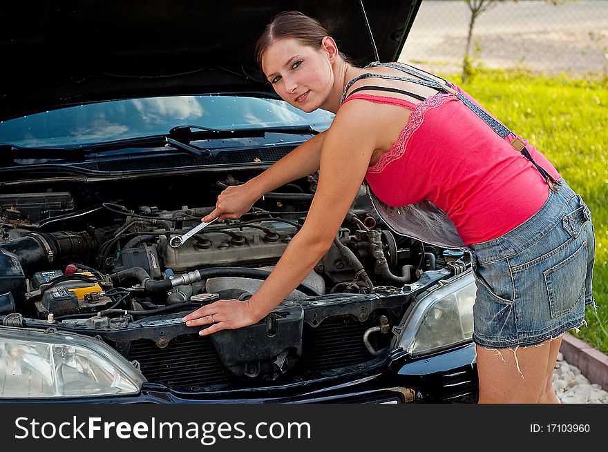 Young woman repairing her car. Young woman repairing her car