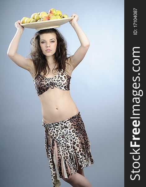 Girl carrying plate with apples and pears on head. Girl carrying plate with apples and pears on head