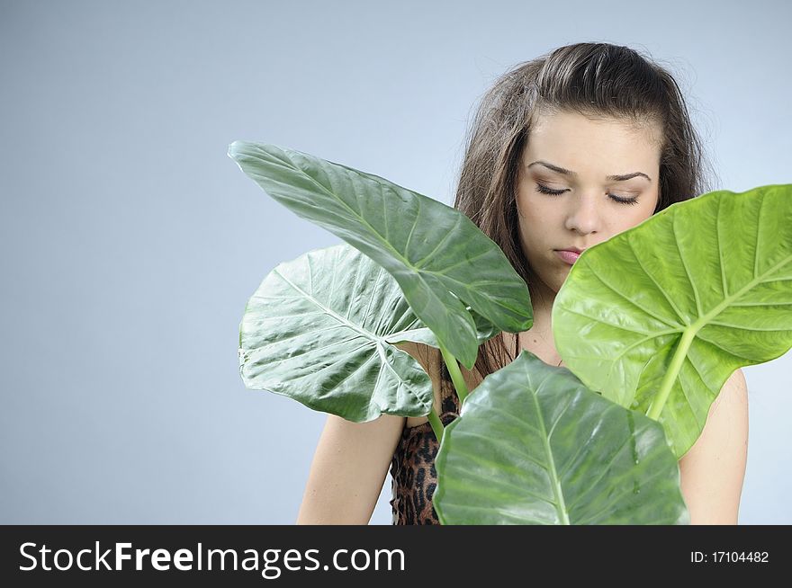 White girl posing in studio with green leaves. White girl posing in studio with green leaves
