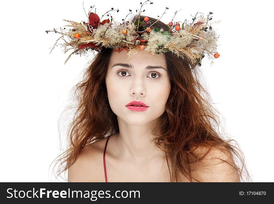 Beautiful young woman in natural wreath over white