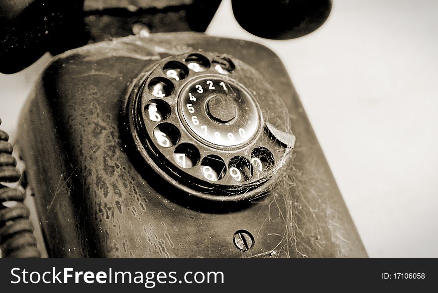 Black disc phone on white wall, vintage object. Black disc phone on white wall, vintage object