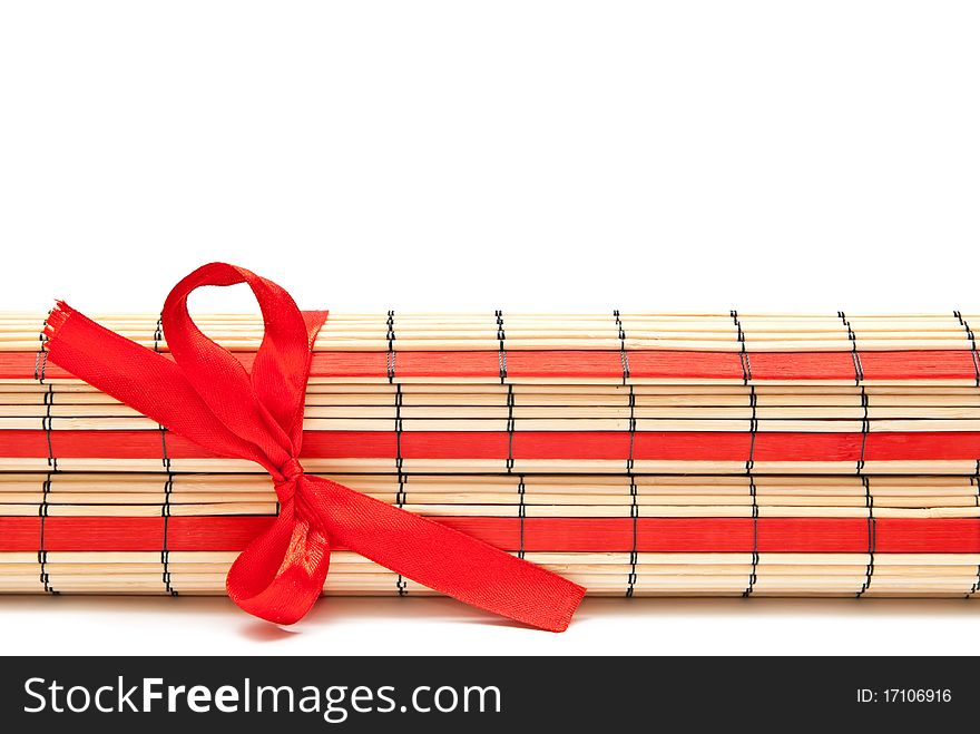 Rolled red bamboo mat isolated on white background