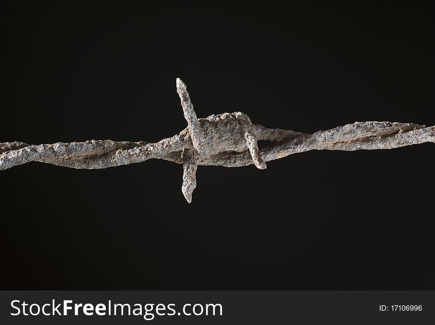 One rusty barbed wire on black background