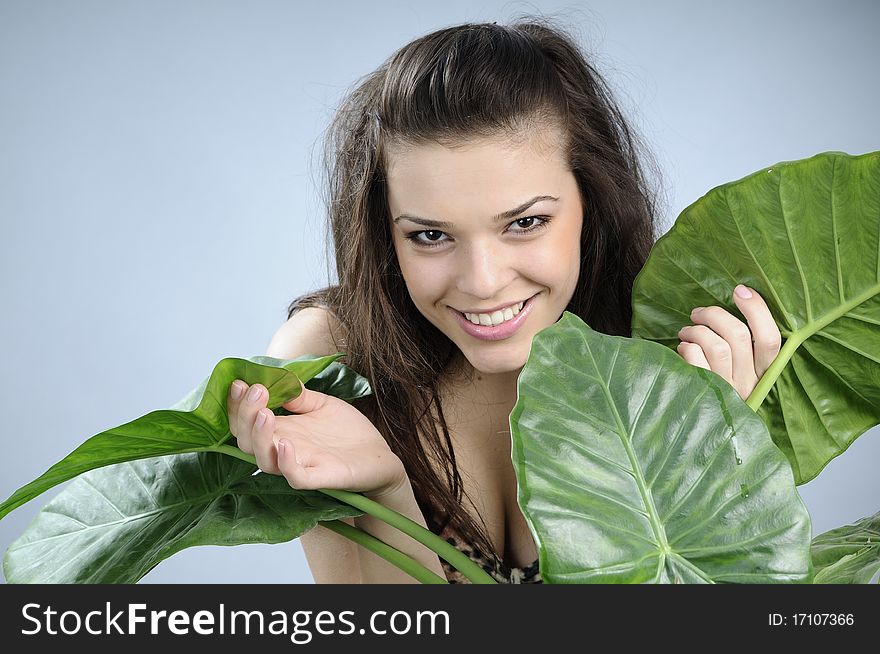 White girl posing in studio with green leaves. White girl posing in studio with green leaves
