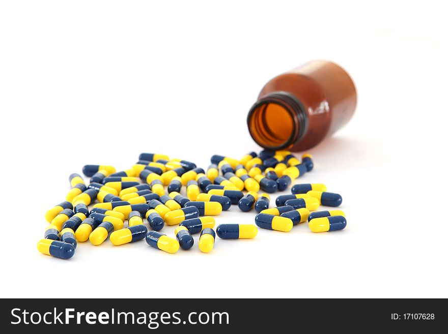 Isolated capsules spilling out on white