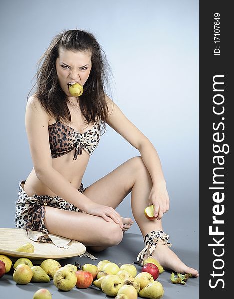 White hungry prehistoric girl preparing to eat fruits. White hungry prehistoric girl preparing to eat fruits