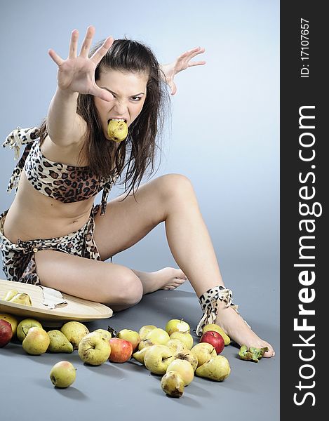 White hungry prehistoric girl eating fruit and challenging. White hungry prehistoric girl eating fruit and challenging