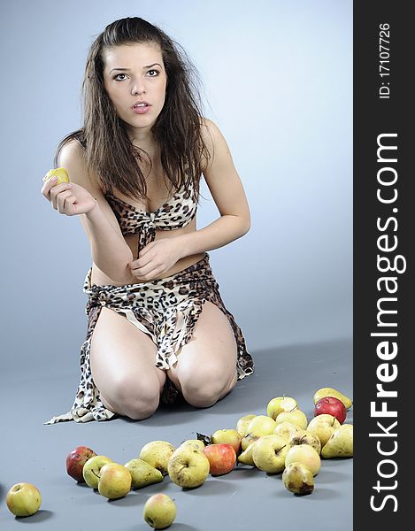 White hungry prehistoric girl eating fruit. White hungry prehistoric girl eating fruit