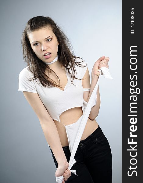 Young adult with torn clothing posing in studio. Young adult with torn clothing posing in studio