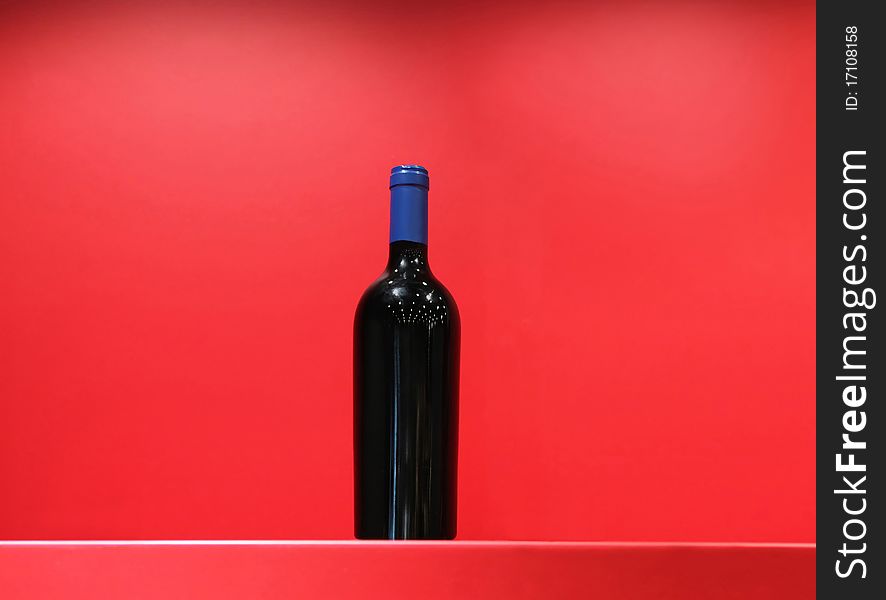 Bottle of elite wine on a show-window in red tones