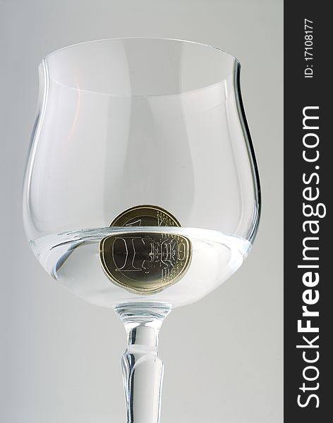 A one Euro coin in a crystal goblet with water. A one Euro coin in a crystal goblet with water