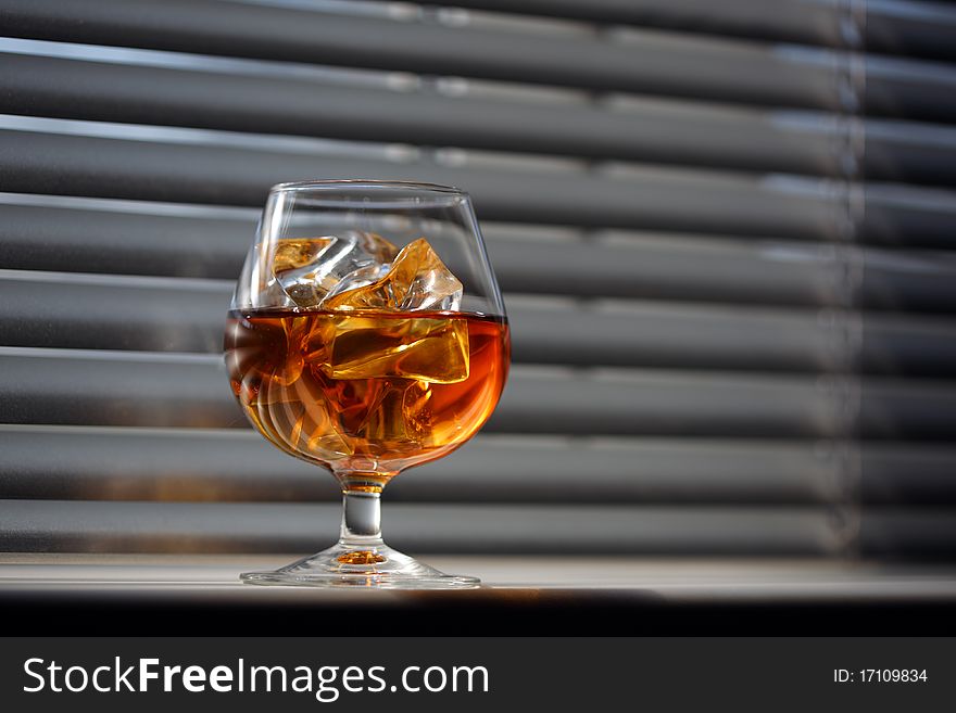 Whisky glass with ice on a window sill