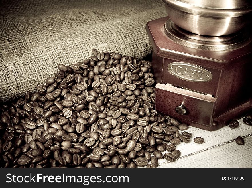 Coffee beans and grinder on sacking in night