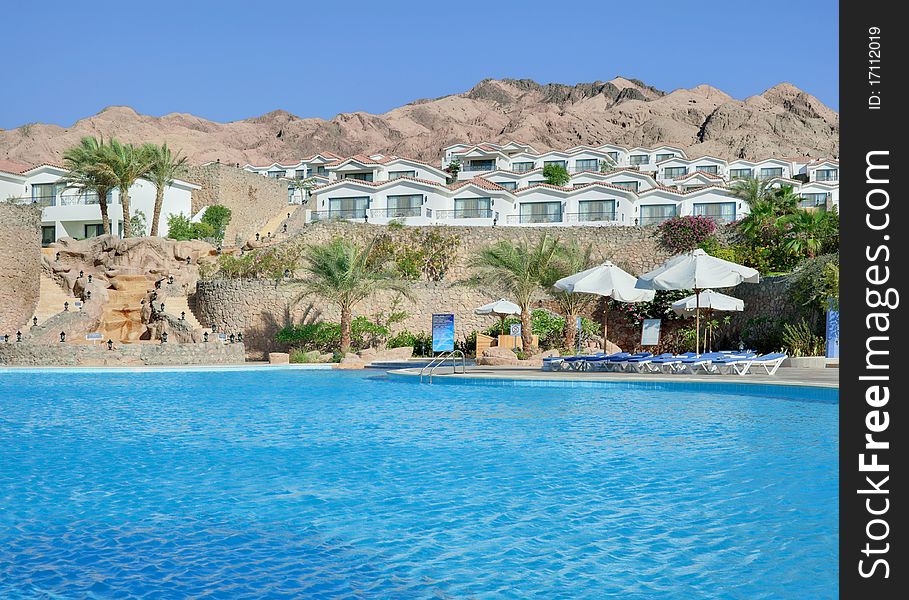 White hotel with swimmingpool and rock behind it. White hotel with swimmingpool and rock behind it