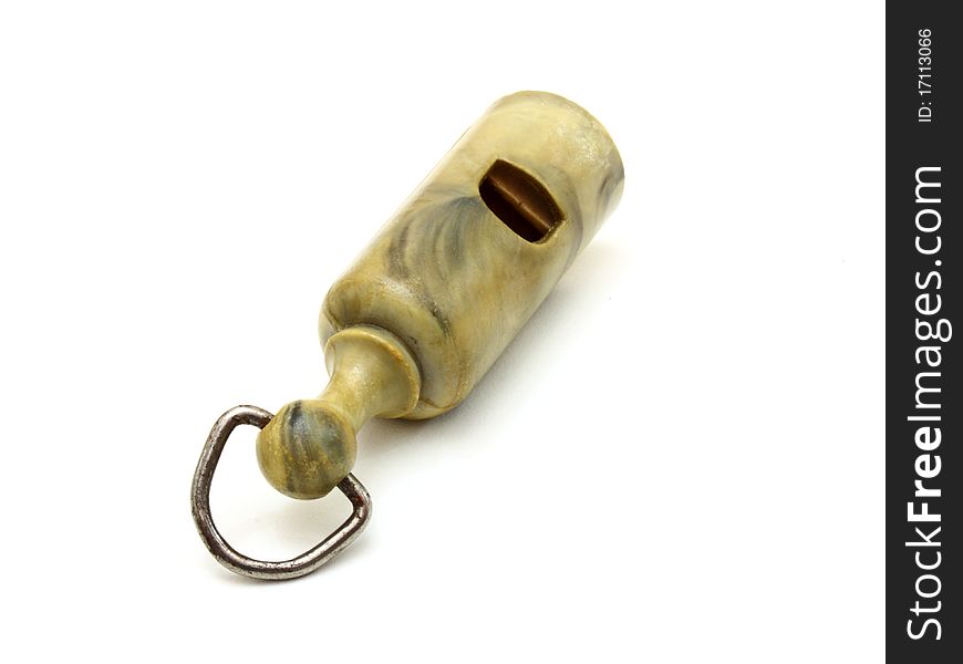 Simple plastic whistle lies on a white background