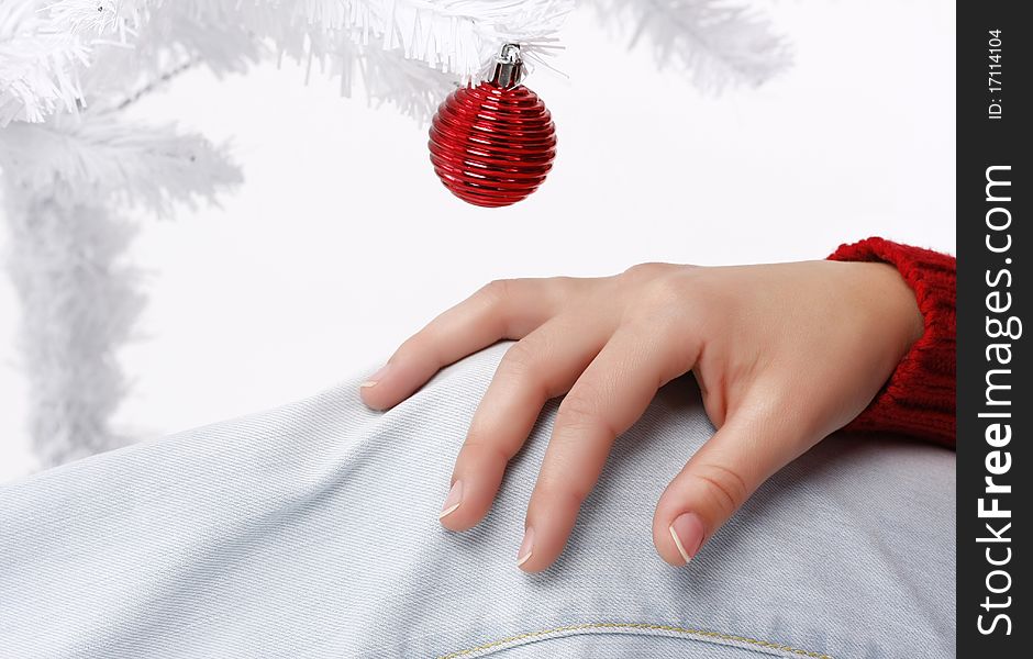 Woman hand with a white christmas tree in the background