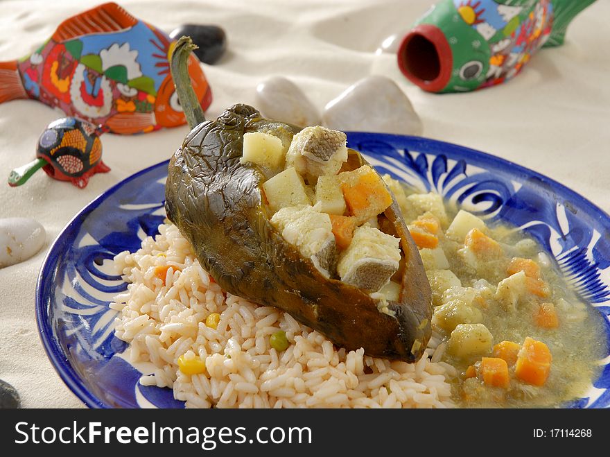 Traditional mexican recipe of chilli filled with tuna and vegetables, served with red rice. Traditional mexican recipe of chilli filled with tuna and vegetables, served with red rice.