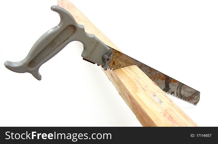 Hacksaw in sawed yellow wooden board on white background