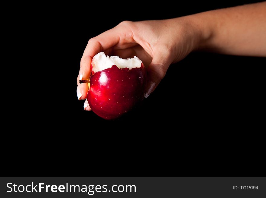 Woman holding red apple on black background