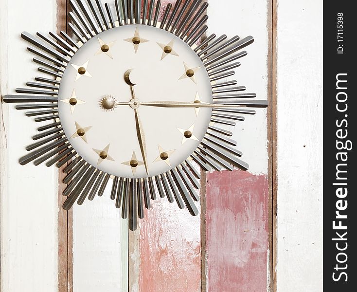 Retro clock with sign of sun moon and stars on wooden wall