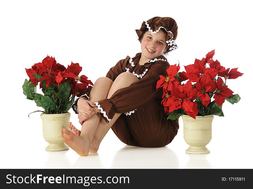 A living Gingerbread Girl sitting barefoot among potted poinsettias. Isolated on white. A living Gingerbread Girl sitting barefoot among potted poinsettias. Isolated on white.