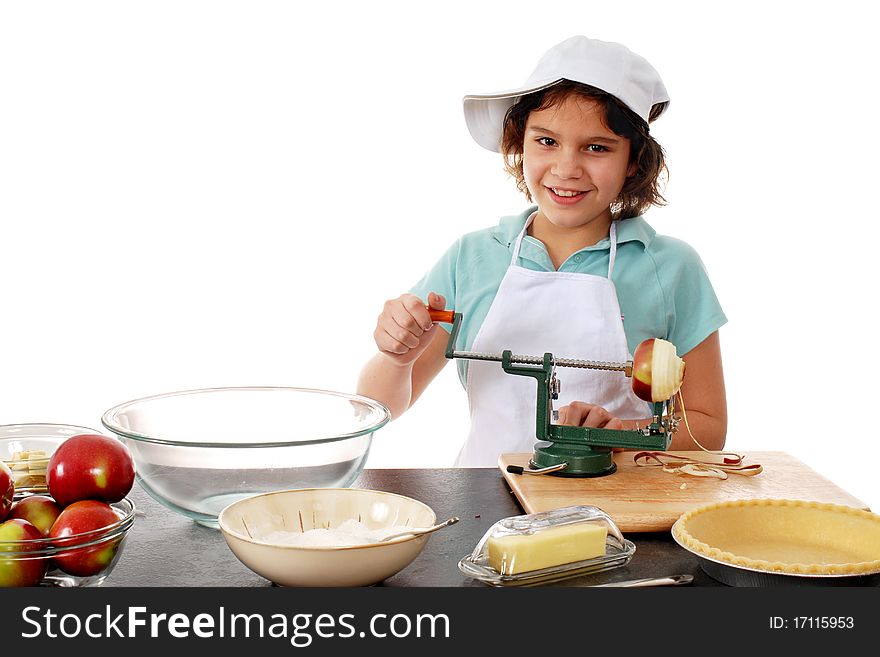 A happy preteen girl peeling apples for the pie she's making. Isolated on white.