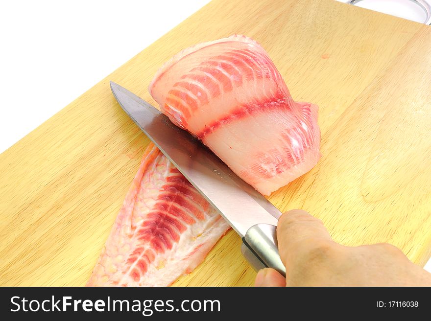 Red tilapia on wood chopping block .