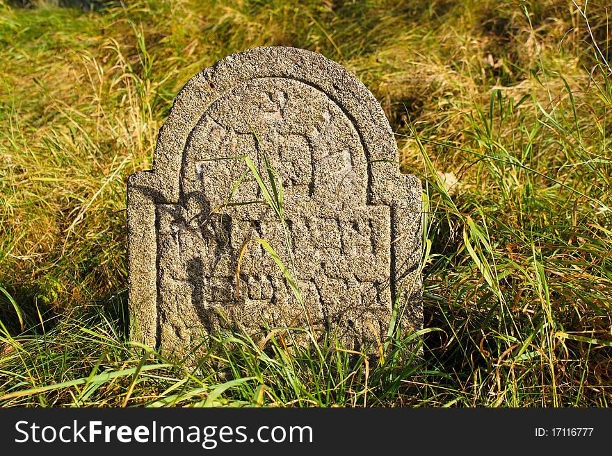 Detail of tomb on forgotten and unkempt Jewish cemetery with the strangers