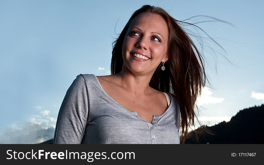 Young beautiful woman with blue sky in the background. Young beautiful woman with blue sky in the background