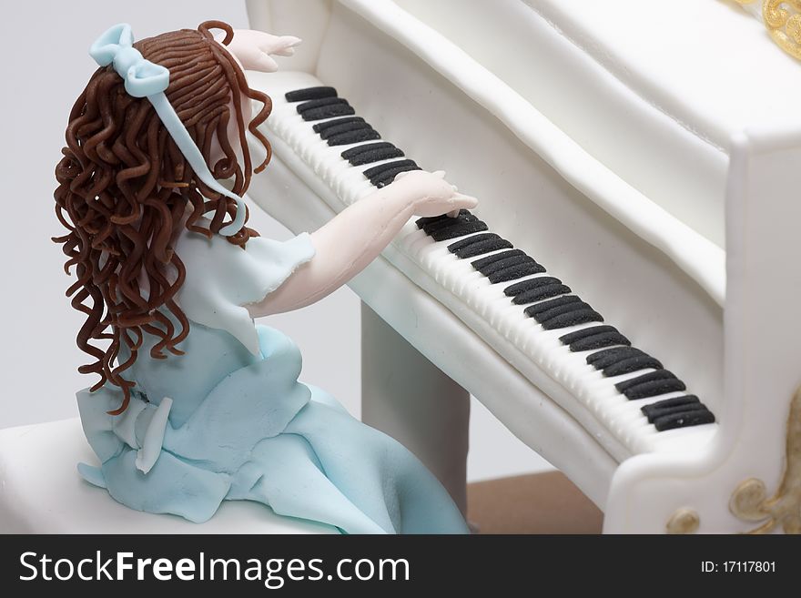 Cake girl in blue dress playing grand piano. Made from marzipan and icing. Cake girl in blue dress playing grand piano. Made from marzipan and icing.