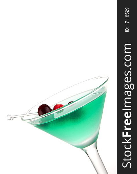 Green Tropical Martini cocktail decorated with cranberries isolated on a white background