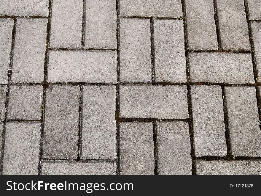 Rough texture of wet block old pavement.