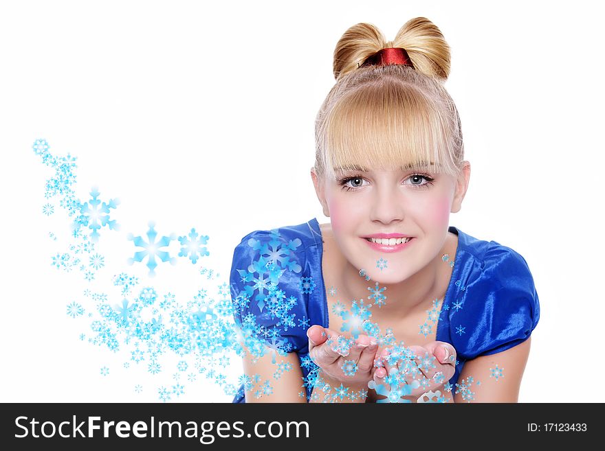 Attractive girl blowing snowflakes from her hands