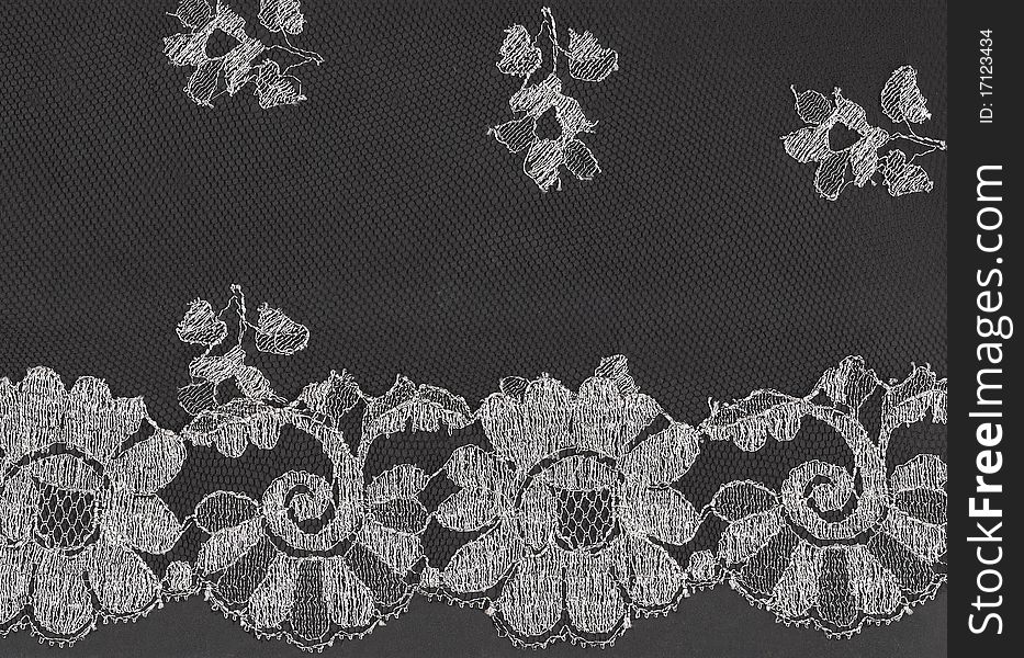 Pattern of black lace fabric with floral motif against black background. Pattern of black lace fabric with floral motif against black background