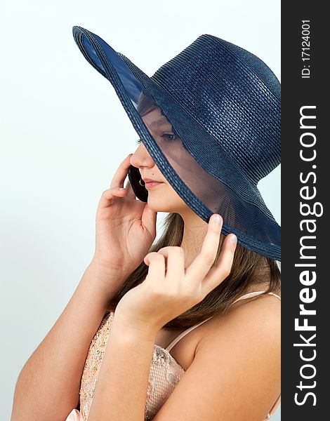 Cute young teenage girl in black hat speaking on mobile phone indoors. Cute young teenage girl in black hat speaking on mobile phone indoors