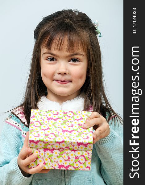 Cute little girl opening a gift box indoors. Cute little girl opening a gift box indoors