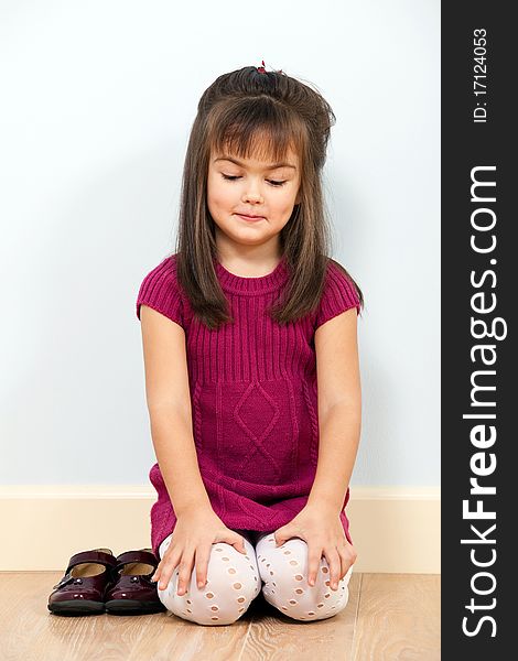 Portrait of sitting cute little girl in red dress indoors. Portrait of sitting cute little girl in red dress indoors