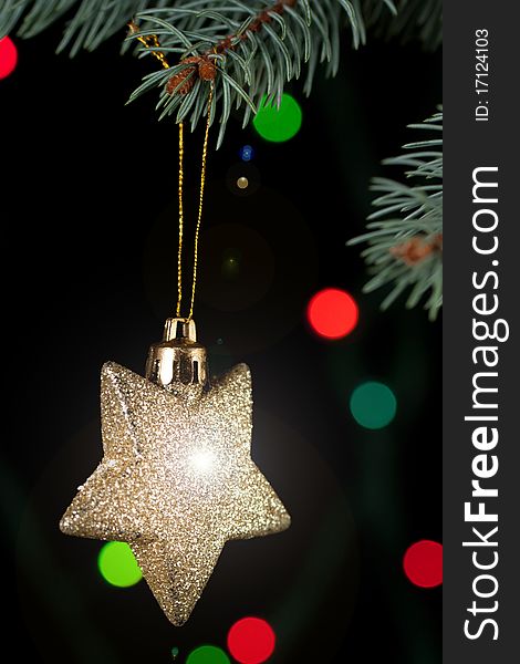 Golden christmas star with a christmas tree on the black background