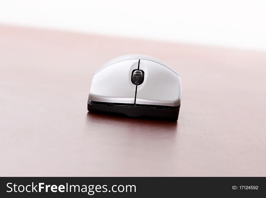 Computer mouse on wooden table over white background