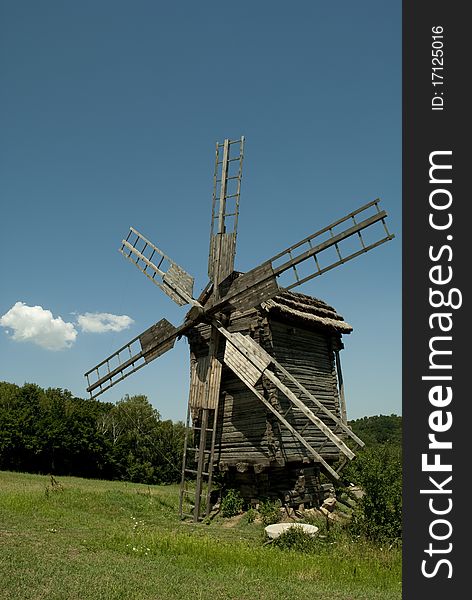 Old wooden wind mill near the forest