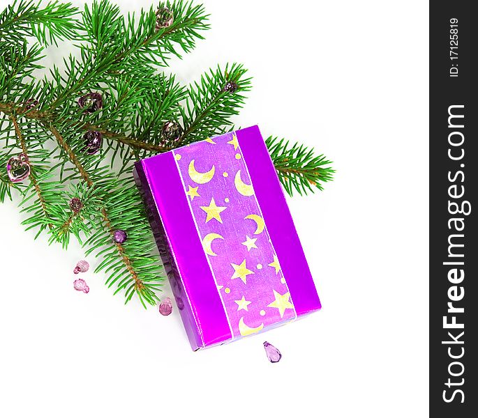 Lilac gift box against a New Year tree branch, white background. Lilac gift box against a New Year tree branch, white background