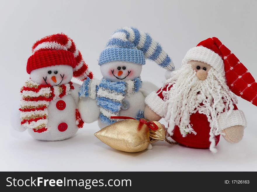 Rag snowmen and Santa Claus with a bag of gifts on the white. Rag snowmen and Santa Claus with a bag of gifts on the white