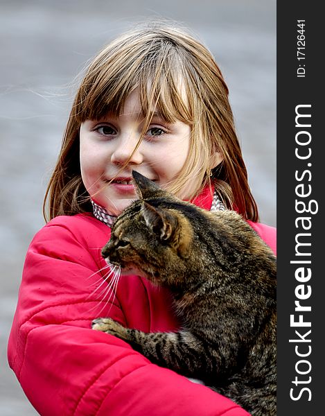 A pretty young blonde girl holds a calico cat. A pretty young blonde girl holds a calico cat.