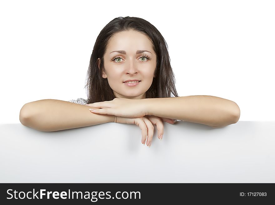 Portrait of an attractive smiling woman leaning on blank board against white background