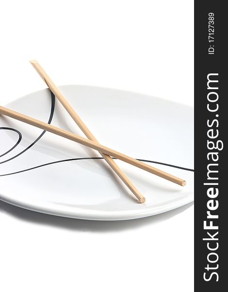 Wood chopsticks and asian style plate against white background. Wood chopsticks and asian style plate against white background